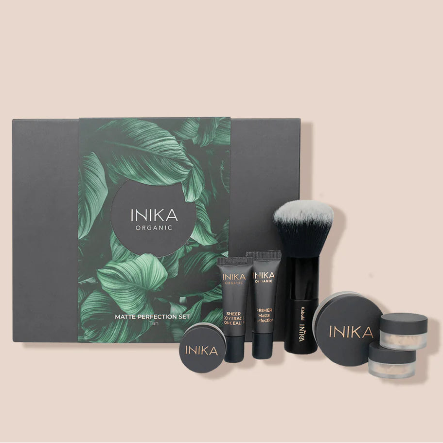 INIKA organic beauty product set with a black box featuring green leaf design on a beige background